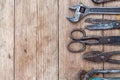 Close up view vintage rusted tools on old wooden table: pliers, pipe wrench, screwdriver, hammer, metal shears, saws and other. Royalty Free Stock Photo