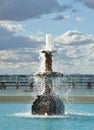 Water fountain with swimming pool softly blurred in background Royalty Free Stock Photo