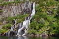 A close-up view of a waterfall in Trollfjorden, Lofoten, Norway, where water streams over moss-covered rocks into the fjord Royalty Free Stock Photo