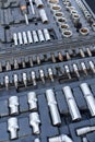 Close-up view of a well-organized toolbox containing various sizes of sockets, socket wrenches, and other related tools. The tools