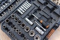 Close-up view of a well-organized toolbox containing various sizes of sockets, socket wrenches, and other related tools. The tools