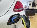Close-up view of a white car in the process of being electrically charged Royalty Free Stock Photo