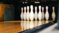 Close-up view of white pins standing in th end of bowling alley lane and rolling bowling ball in a sport club. Media Royalty Free Stock Photo