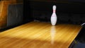 Close-up view of white pins standing in th end of bowling alley lane and rolling bowling ball in a sport club. Media