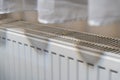 A close-up view of a white radiator beneath a sheer curtain, showcasing the design and functionality of home heating sys Royalty Free Stock Photo