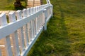 Close-up view of a white wooden fence installed against the sunlight on the lawn Royalty Free Stock Photo