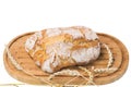 Close up  view of whole grain loaf white bread and wheat ears on a cutting board isolated on white background Royalty Free Stock Photo