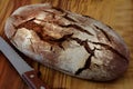 Whole loaf of a country bread on a wooden cutting board with a k Royalty Free Stock Photo