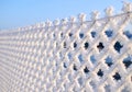 Close-up view of a wire fence with frost with ice crystals under a blue sky with a blurred background Royalty Free Stock Photo