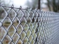 Close-up view of a wire fence with frost with ice crystals under a blue sky with a blurred background Royalty Free Stock Photo