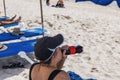 Close-up view of woman drinking soda from bottle on sand beach. Royalty Free Stock Photo