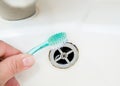 Close up view of woman hand cleaning bathroom sink with toothbrush. Home cleaning hack. Royalty Free Stock Photo