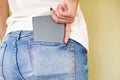 Close-up view of woman hand pulling gray wallet from back pocket of jeans trousers Royalty Free Stock Photo