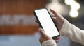 Close up view of woman hands holding mock up smart phone with office blurred background. Royalty Free Stock Photo