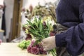Close up view of a woman holding a bouquet of colourful flowers in a flowers shop in town