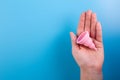 Close up view of woman holding pink menstrual cup isolated over blue background, woman\'s period