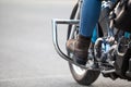 Close-up view at the woman legs with protective boots on stands of chopper motorcycle, copyspace Royalty Free Stock Photo