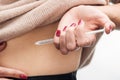 Close up view of woman making injection in stomach with syringe isolated Royalty Free Stock Photo