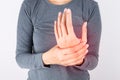 Close-up view of a woman massaging her painful hand on a white background. Hands of asian young girl have inflammation