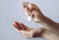 Close up view of woman person using small portable antibacterial hand sanitizer on hands.