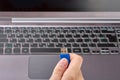 Close-up view of woman`s hand with blue USB Flash memory media or disc. Soft focus laptop with keyboard on background Royalty Free Stock Photo