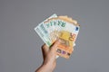 Close up view of a woman`s hand holding a pile of euro banknotes   money on a gray background . The economic impact of coronaviru Royalty Free Stock Photo