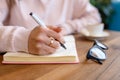 Close-up view of a woman`s hand with a pen, writes in a notebook Royalty Free Stock Photo