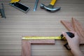 Close up view of a woman is hands measuring wooden plank with a Tape measure with a set collection Royalty Free Stock Photo