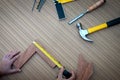 Close up view of a woman is hands measuring wooden plank with a Tape measure with a set collection of working hand tools Royalty Free Stock Photo