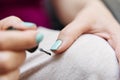 Close-up view of a woman`s hands painting her nails with blue-green nail polish. Concept of body care and beauty