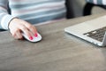 Female hand computer mouse in front of laptop Royalty Free Stock Photo