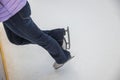 Close-up view of woman standing near barrier on ice rink in sports complex wearing her white figure skates Royalty Free Stock Photo