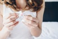 Close-up view of woman tearing the condom wrapper before using with her partner.