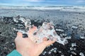 Close up view of woman tourist holding glacier ice on hand.
