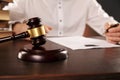 Close up view of wooden gavel. Male attorney working with paper documents. Royalty Free Stock Photo