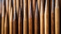 A close-up view of wooden skewers lined up in a row, with the texture of the wood grains clearly visible