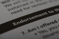 Close up view of the word ENDORSEMENT. An endorsement is a form of approval, support, or recommendation given to a product
