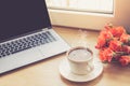 Close up view on work desk interior with a laptop computer and morning coffee cup. Toned photo of work desk with computer and coff Royalty Free Stock Photo