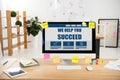 close up view of workplace with we help you succeed inscription on computer screen and sticky notes Royalty Free Stock Photo