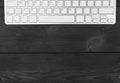 Close up view of a workplace with wireless computer keyboard, keys on old black wooden table background.