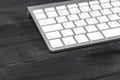 Close up view of a workplace with wireless computer keyboard, keys on old black wooden table background.