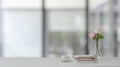 Close up view of workspace with books, flower vase and coffee cup on white table with blurred background Royalty Free Stock Photo