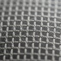 A close-up view of a woven mesh fabric displaying a grid pattern. The fabric consists of intersectin Royalty Free Stock Photo