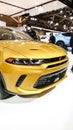 Close up view of yellow dodge GT car on display. Vertical. Crowds looking at new car models at Auto show. National Canadian Auto