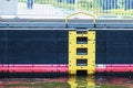 Close-up view of the yellow marked rescue ladder on the smooth high wall of an airlock