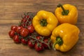 Close up view of yellow paprika and red cherry tomatoes  on wooden background. Healthy food concept Royalty Free Stock Photo