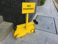Close up view of a yellow wheel clamp on a sidewalk to use on parking offenders Royalty Free Stock Photo
