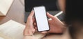 Close-up view of young businesswoman working on her project while using smartphone in comfortable office Royalty Free Stock Photo