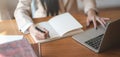 Close-up view of young businesswoman working on her project and writing her ideas in notebook in comfortable office Royalty Free Stock Photo