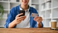 Close up view of young man doing an online shopping with smartphone Royalty Free Stock Photo